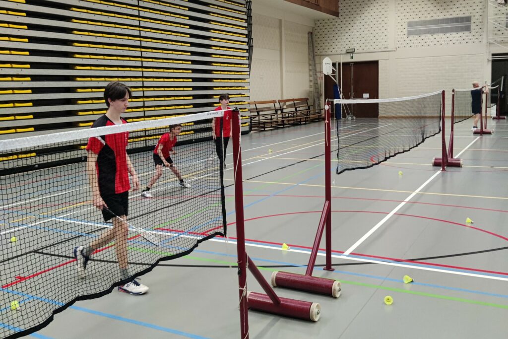 Jeugd die badminton spelen bij BC De Valkaart te Oostkamp tijdens de badmintontraining